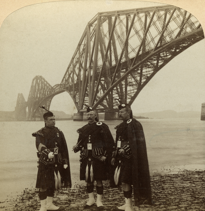 Men in Highland Dress in Front of the Forth Bridge Scotland | Getty Images Photo by The Print Collector